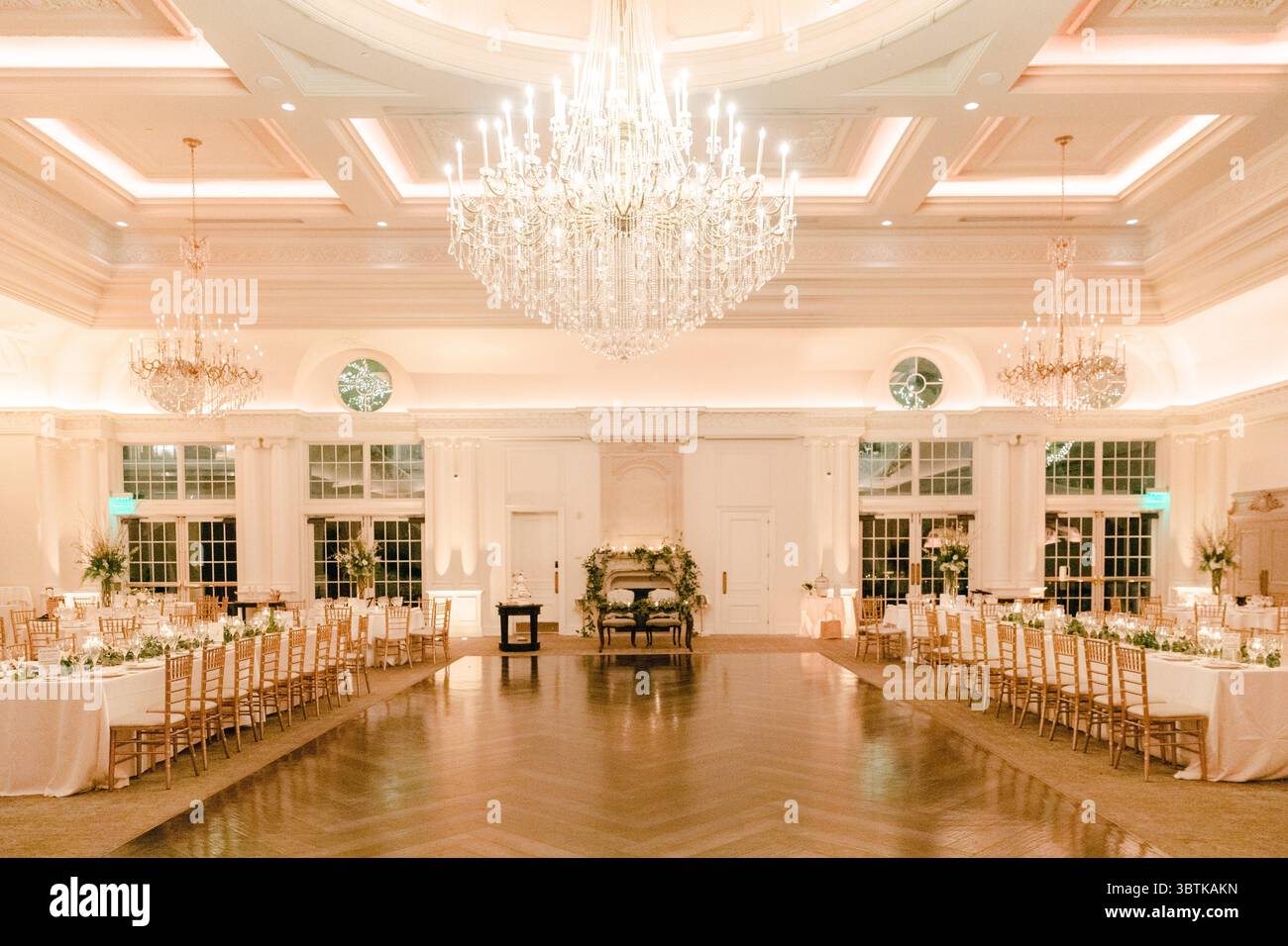 La sala banchetti presenta splendidi arredi, tavoli eleganti e luci soffuse, perfette per un ricevimento di nozze. Foto Stock