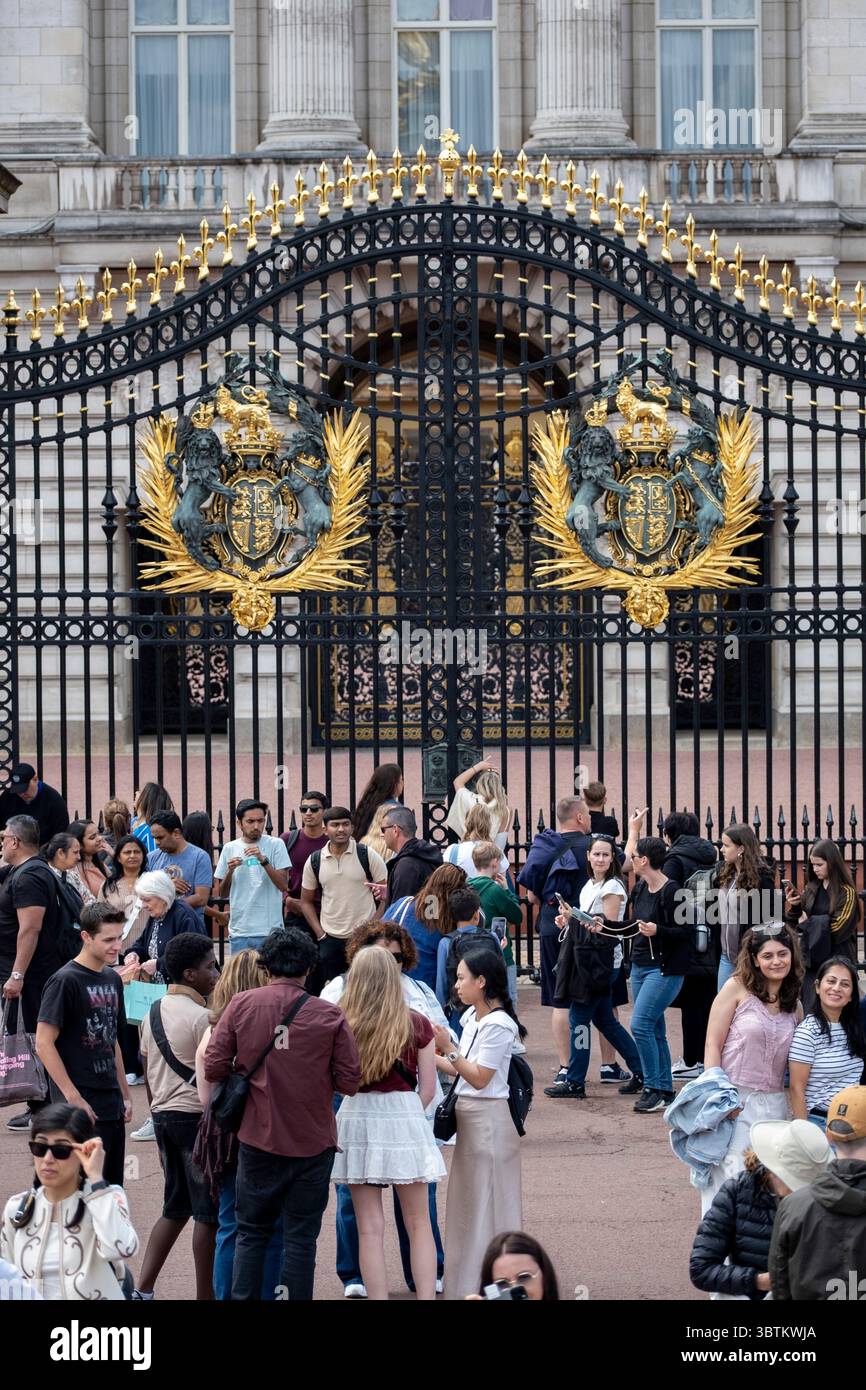 Turisti e visitatori nazionali alle porte fuori Buckingham Palace il 7 luglio 2025 a Londra, Regno Unito. Londra è una delle principali destinazioni turistiche al mondo, con molte famose attrazioni turistiche. La città attira ogni anno milioni di visitatori internazionali, nonché turisti nazionali e visitatori di un giorno. Il settore viaggi e turismo nel Regno Unito contribuisce notevolmente all'economia, con il settore turistico che impiega circa 700.000 persone. Foto Stock