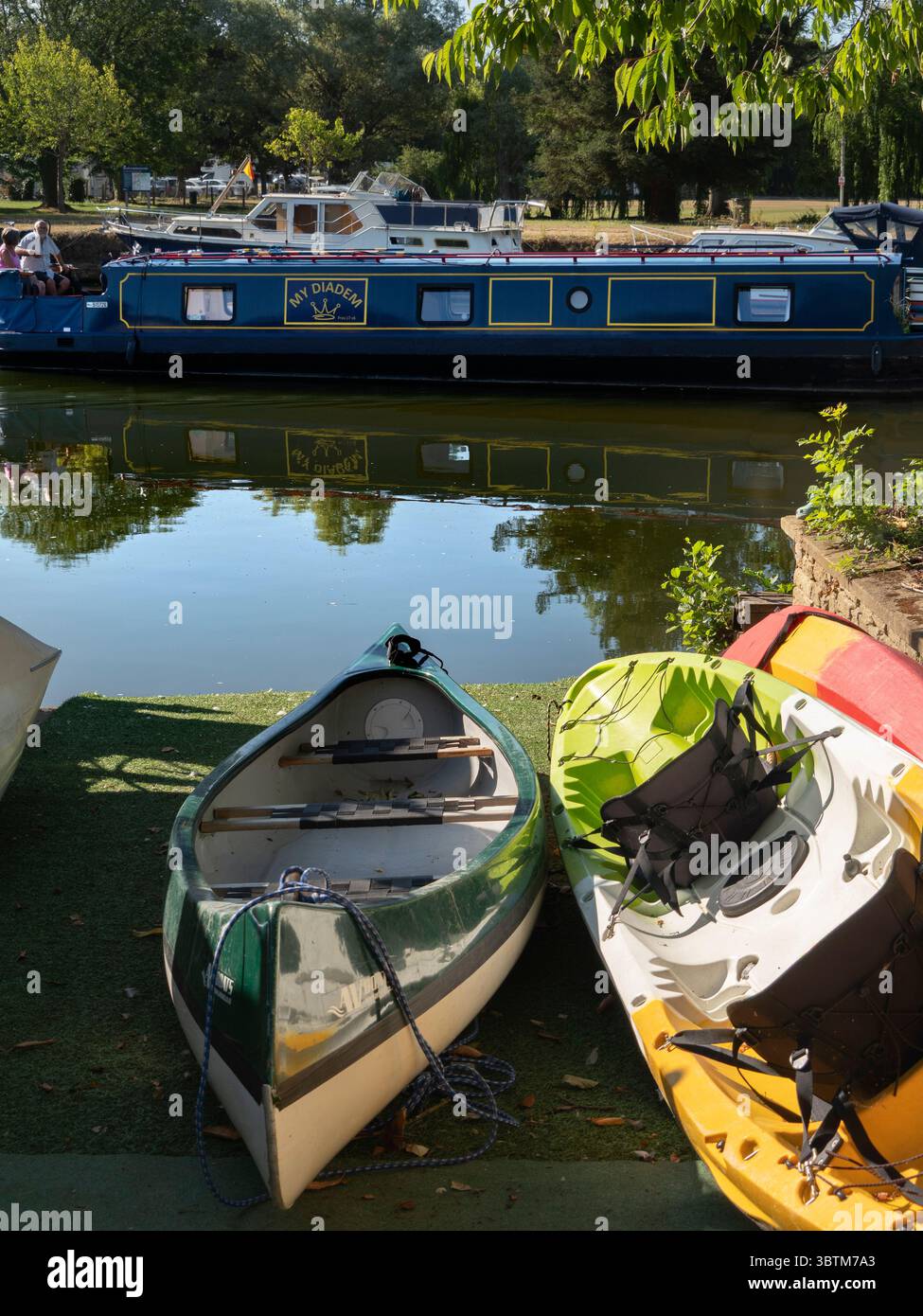 Canoe e case galleggianti passando per Nag's Head Island, Abingdon. Abingdon sostiene di essere la città più antica d'Inghilterra. E il Tamigi attraversa il suo cuore. Nags Head Island si trova sul fiume e si trova tra i suoi due famosi ponti antichi. Foto Stock