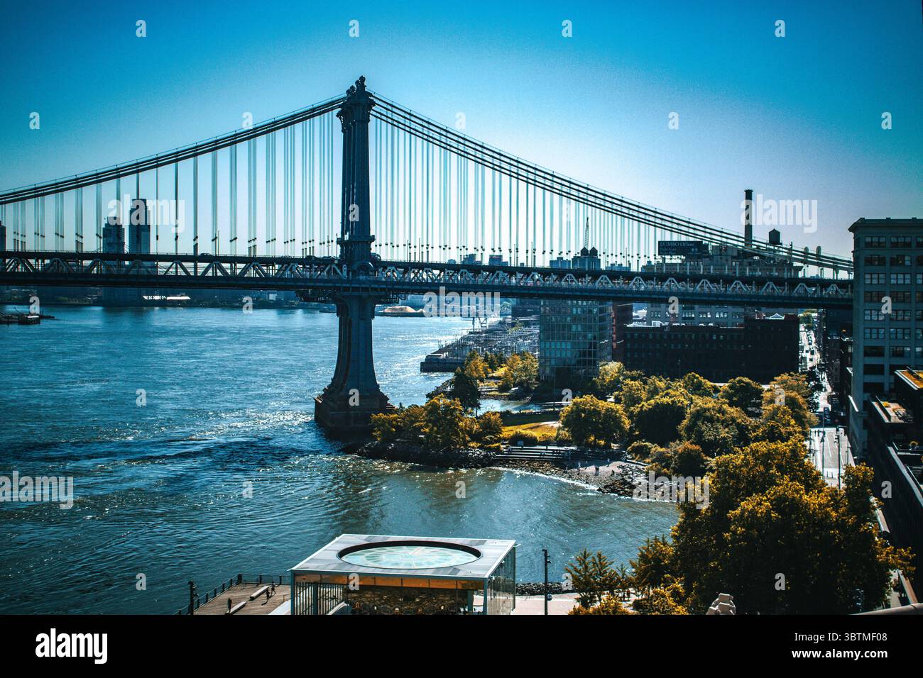 La vista del ponte di Brooklyn dal lungomare, con splendidi cieli blu. Ponte sospeso in acciaio cablato da Manhattan a Brooklyn, New York. Foto Stock