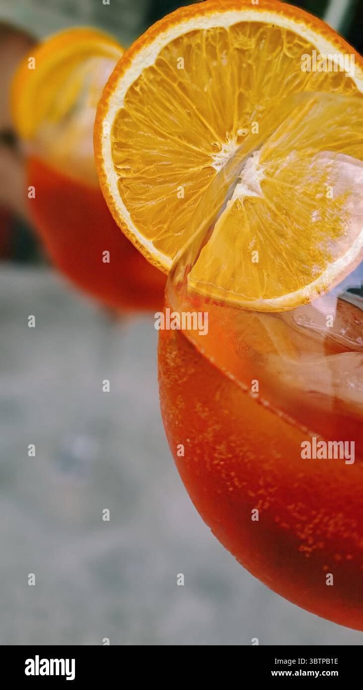 Primo piano di un cocktail Aperol Spritz con una fetta di arancia guarnire in un bicchiere. Foto Stock Primo piano di un cocktail Aperol Spritz con una fetta di arancia guarnire in un bicchiere. Foto Stock
