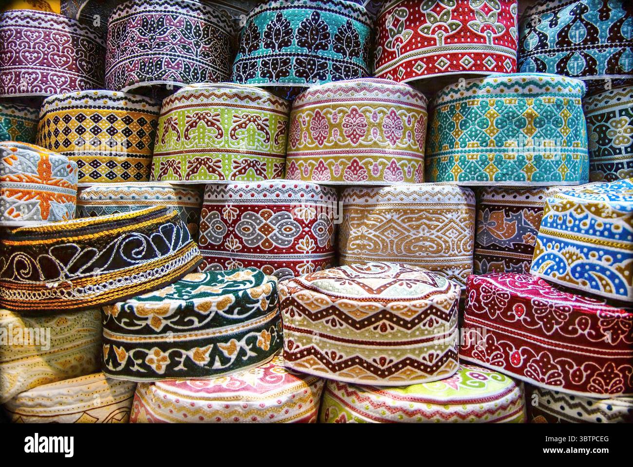 Pila di cappelli ricamati tradizionali in vari colori e motivi. Vista ravvicinata del copricapo decorativo islamico. Foto Stock