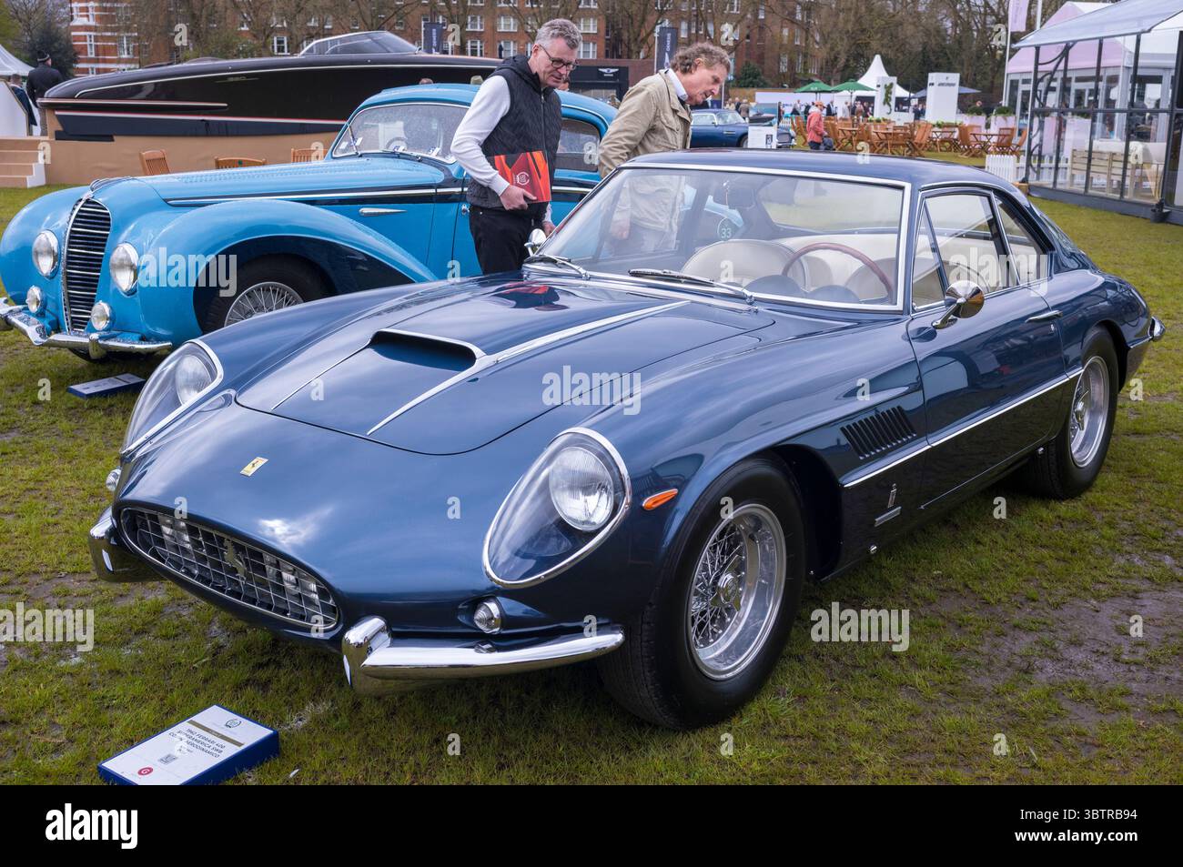I visitatori visitano la tradizionale auto sportiva Ferrari 400 Superamerica SWB Coupé Aerodinamico del 1962 in vendita al Salon prive London Concours de Vente Classic Foto Stock