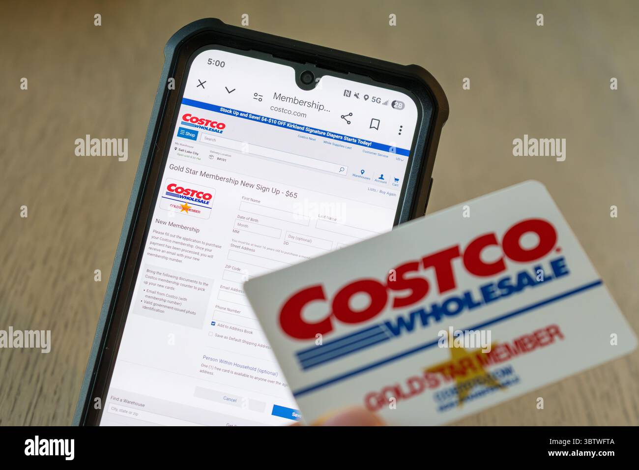 Salt Lake City, Utah, 15 luglio 2025 — la carta Costco Gold Star Member si trova di fronte allo schermo del telefono con la pagina di iscrizione Costco.com aperta. Foto Stock