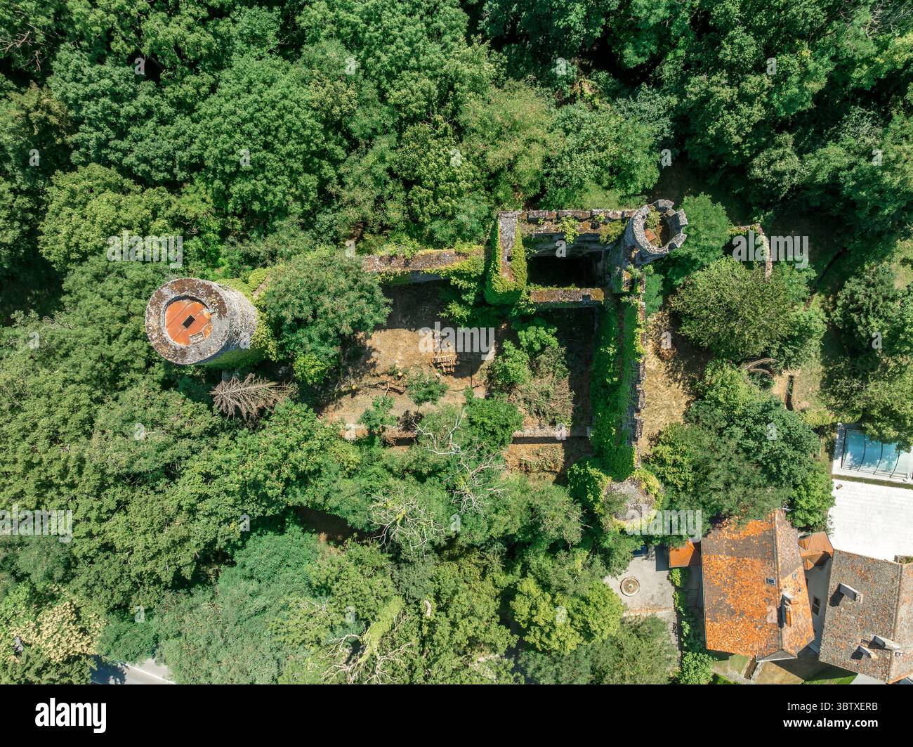 Vista aerea del castello Rochette in Savoia, in cima a una collina, con mura rotonde che si innalzano sopra la strada commerciale sottostante Foto Stock