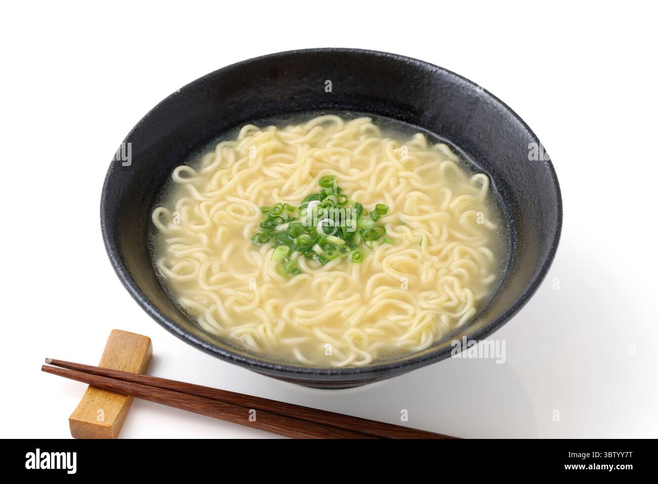 Spaghetti di ramen salato in una ciotola con bacchette su sfondo bianco Foto Stock