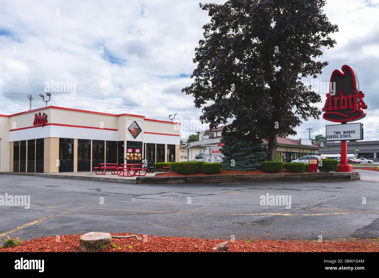 Utica, NY - 8 luglio 2025: Vista ultra ampia dell'esterno dell'edificio del ristorante Arby's e del cartello del palo, i negozi di sandwich sono noti per la carne arrosto lenta, il tacchino, Foto Stock
