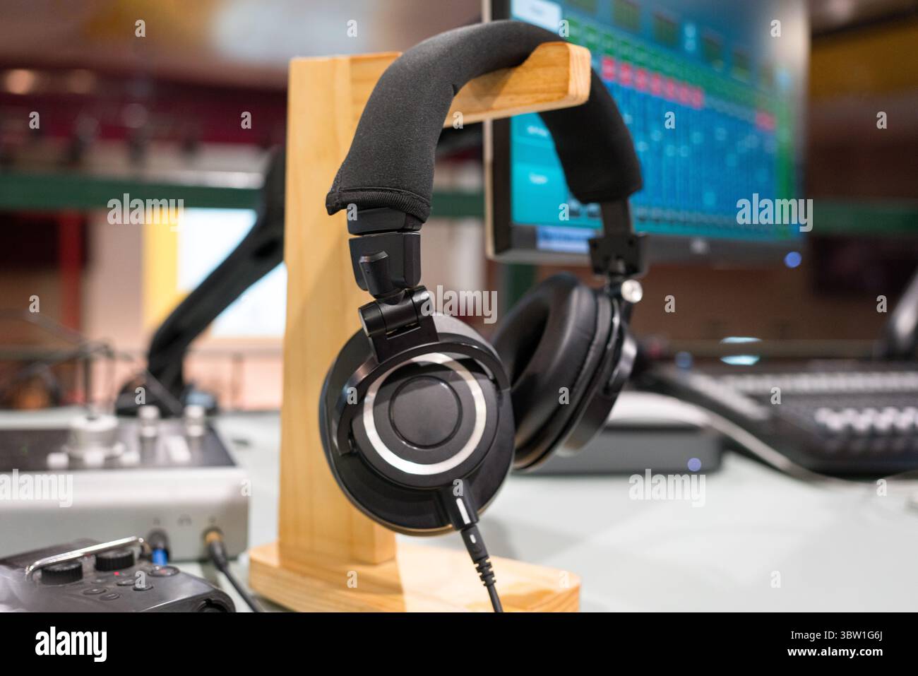 Cuffia con mixer e schermo monitor sullo sfondo. Audio, musica e intrattenimento. Foto Stock