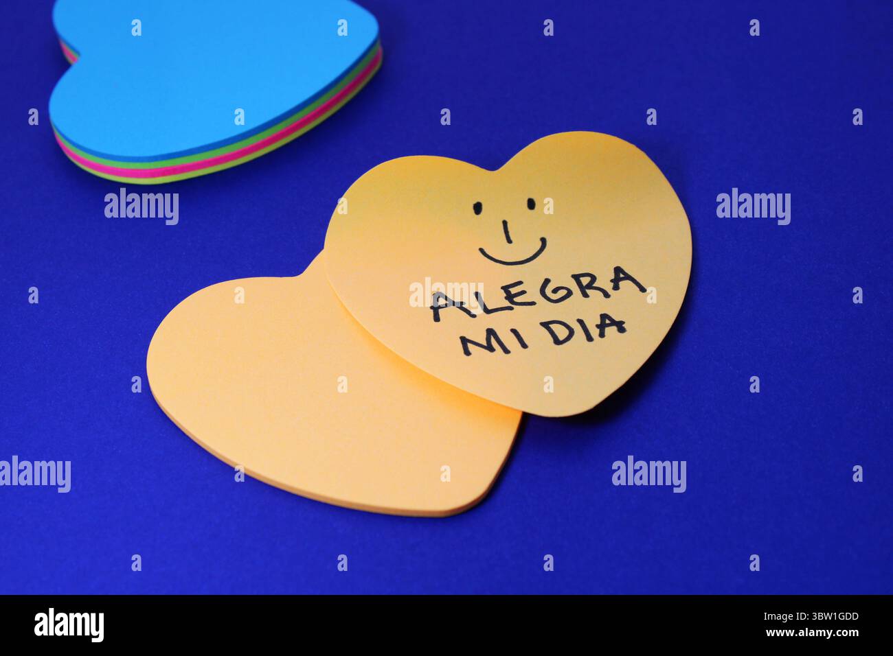 FACCIA FELICE E FRASE ILLUMINANO LA MIA GIORNATA, note adesive a forma di cuore (testo in spagnolo) Foto Stock