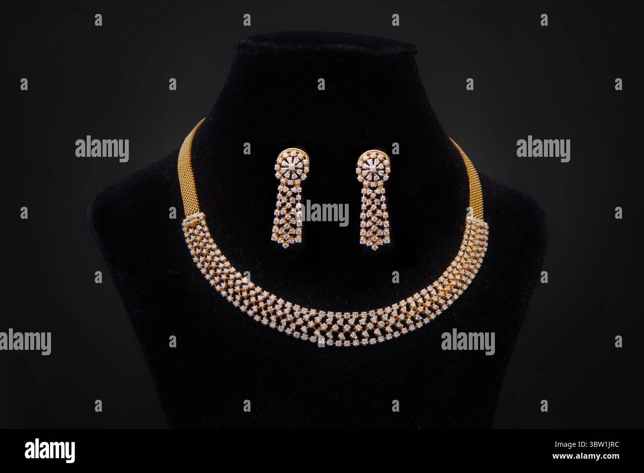 Elegante collana in oro e diamanti con orecchini abbinati su display in velluto nero Foto Stock