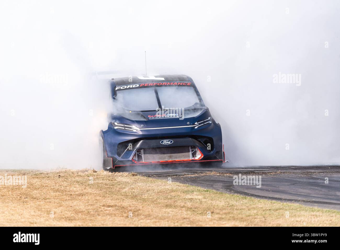 2023 Ford e Transit Supervan 4,2 furgone elettrico personalizzato che guida su pista per arrampicata Goodwood Festival of Speed 2025 Motorsport event. Bruciare il fumo degli pneumatici Foto Stock