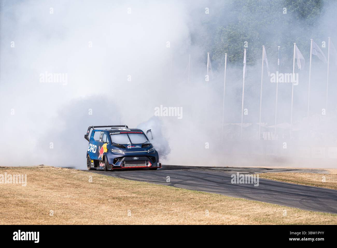 2023 Ford e Transit Supervan 4,2 furgone elettrico personalizzato che guida su pista per arrampicata Goodwood Festival of Speed 2025 Motorsport event. Bruciare il fumo degli pneumatici Foto Stock