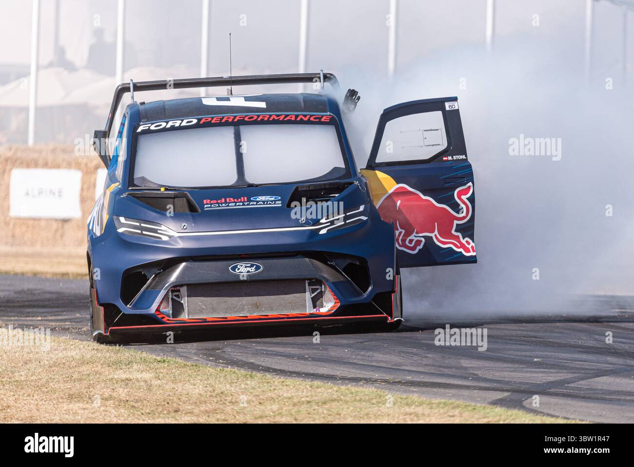 2023 Ford e Transit Supervan 4,2 furgone elettrico personalizzato che guida su pista per arrampicata Goodwood Festival of Speed 2025 Motorsport event. Bruciare il fumo degli pneumatici Foto Stock