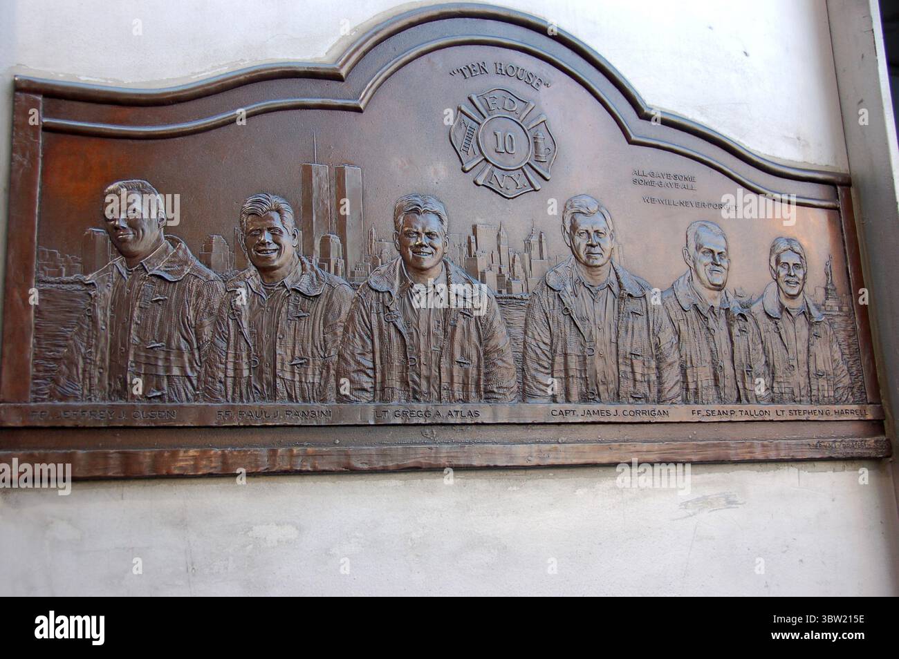 Targa commemorativa in bronzo in onore dei vigili del fuoco della FDNY Ten House morti negli attacchi del 9/11, con le torri gemelle incise sullo sfondo Foto Stock