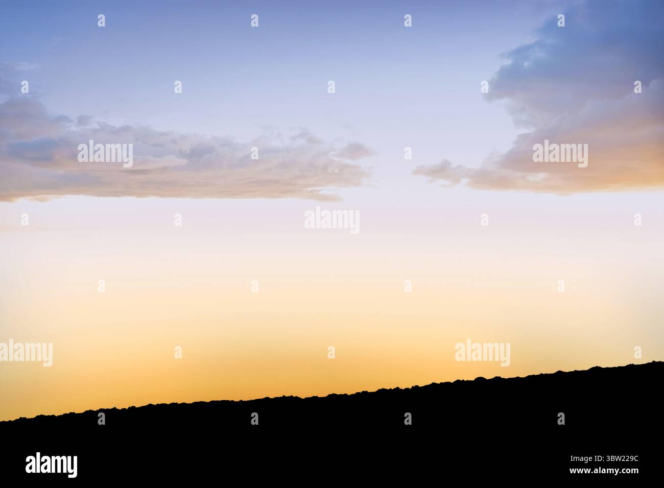 Il cielo gradiente si sta spostando dal giallo dorato caldo al blu pallido con un design piatto e una cresta sagomata Foto Stock