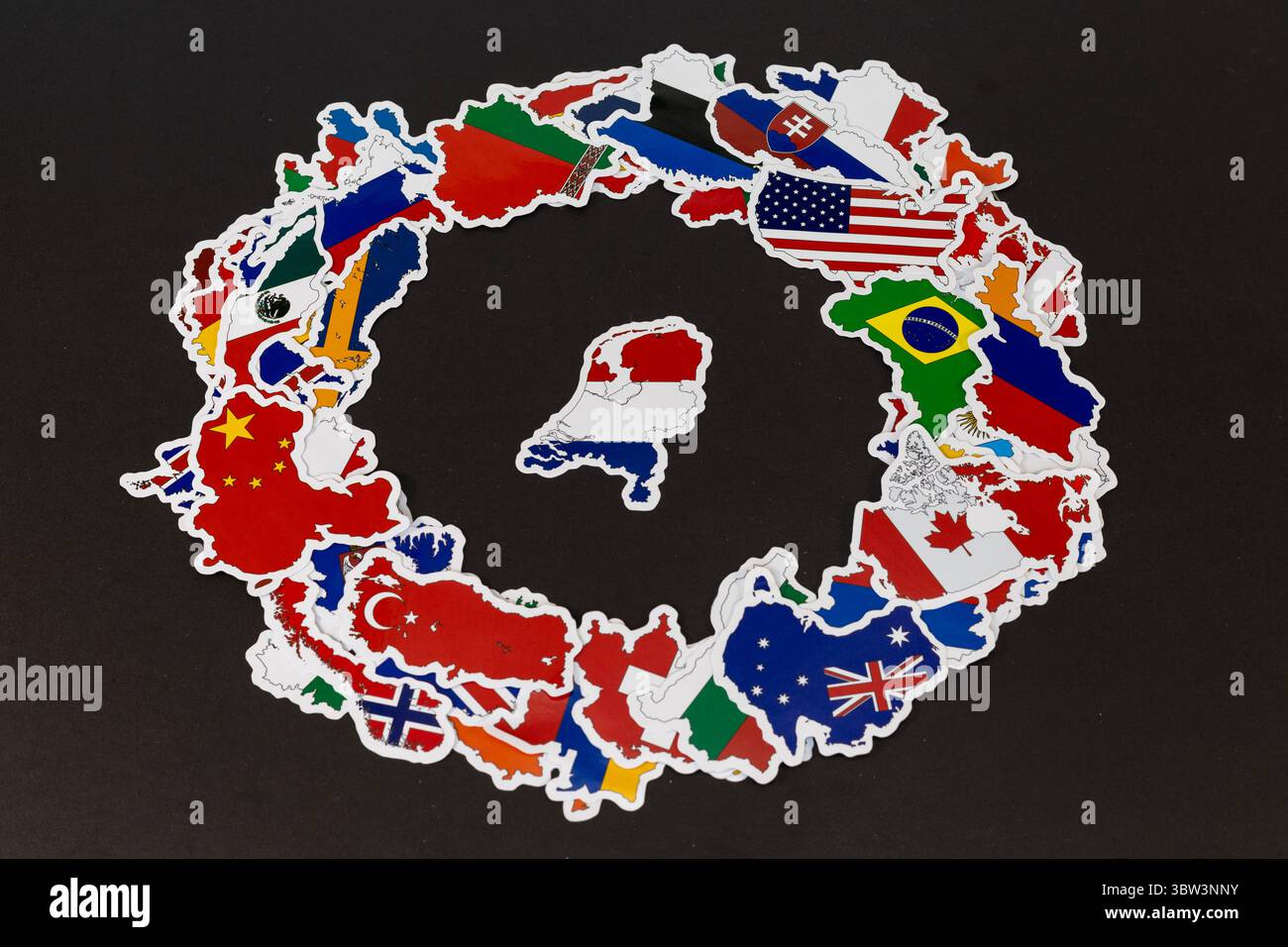 Mappa dei Paesi Bassi circondata da paesi del mondo in adesivi bandiera su sfondo nero Foto Stock
