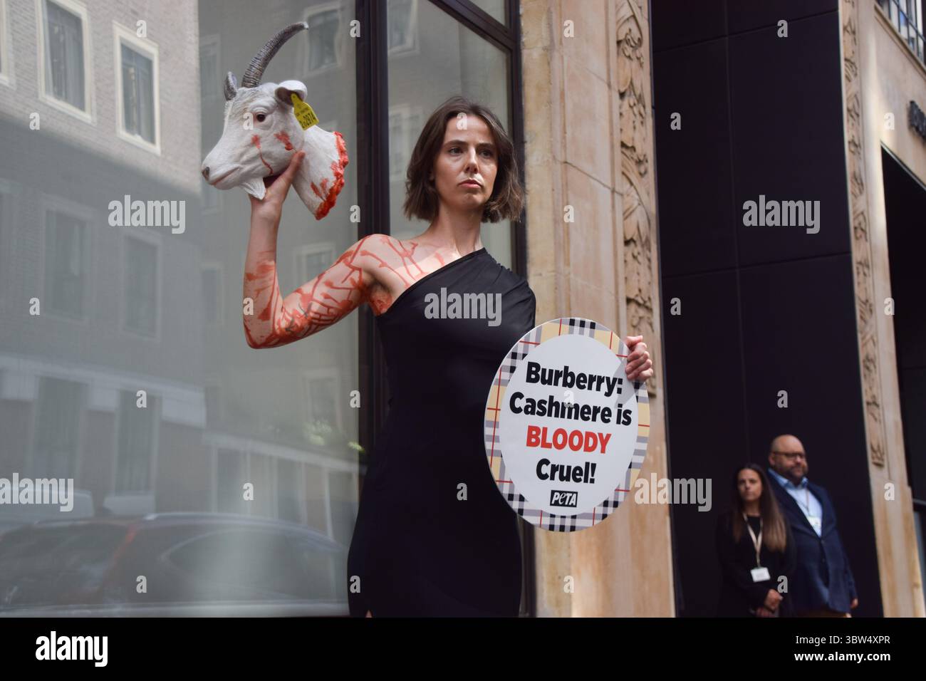 Londra, Regno Unito. 16 luglio 2025. Un attivista della PETA si erge con una "testa di capra recisa" artificiale e un cartello che dice "il cashmere è crudele" fuori dalla sede di Burberry a Horseferry House mentre il gruppo della moda tiene la sua Assemblea generale annuale (AGM). L'azione fa parte della campagna in corso del gruppo per i diritti degli animali che chiede a Burberry di eliminare il cashmere dai suoi prodotti e di utilizzare invece tessuti vegani. Crediti: Vuk Valcic/Alamy Live News Foto Stock