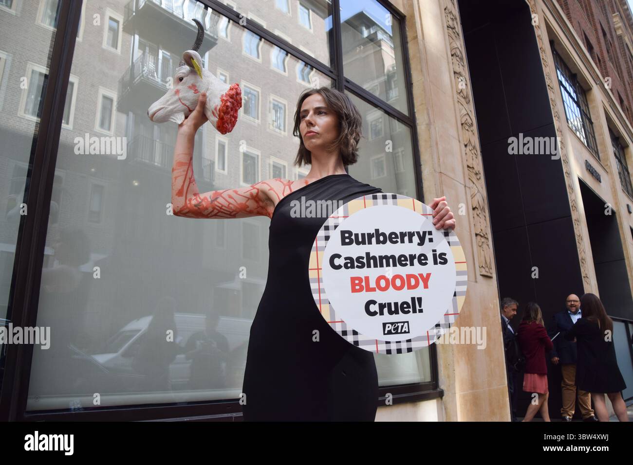 Londra, Regno Unito. 16 luglio 2025. Un attivista della PETA si erge con una "testa di capra recisa" artificiale e un cartello che dice "il cashmere è crudele" fuori dalla sede di Burberry a Horseferry House mentre il gruppo della moda tiene la sua Assemblea generale annuale (AGM). L'azione fa parte della campagna in corso del gruppo per i diritti degli animali che chiede a Burberry di eliminare il cashmere dai suoi prodotti e di utilizzare invece tessuti vegani. Crediti: Vuk Valcic/Alamy Live News Foto Stock