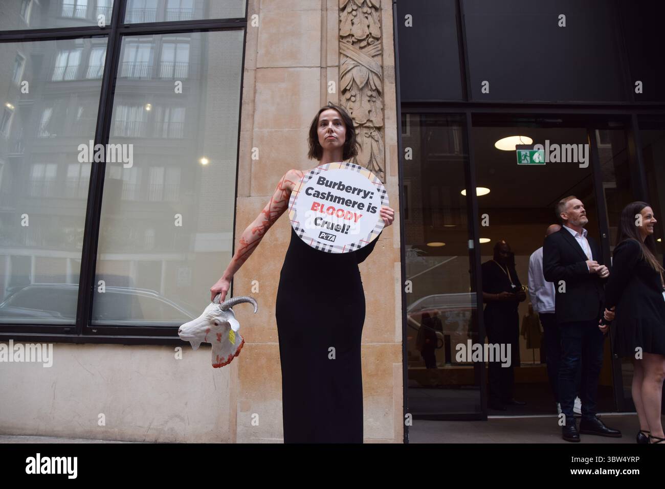 Londra, Regno Unito. 16 luglio 2025. Un attivista della PETA si erge con una "testa di capra recisa" artificiale e un cartello che dice "il cashmere è crudele" fuori dalla sede di Burberry a Horseferry House mentre il gruppo della moda tiene la sua Assemblea generale annuale (AGM). L'azione fa parte della campagna in corso del gruppo per i diritti degli animali che chiede a Burberry di eliminare il cashmere dai suoi prodotti e di utilizzare invece tessuti vegani. Crediti: Vuk Valcic/Alamy Live News Foto Stock
