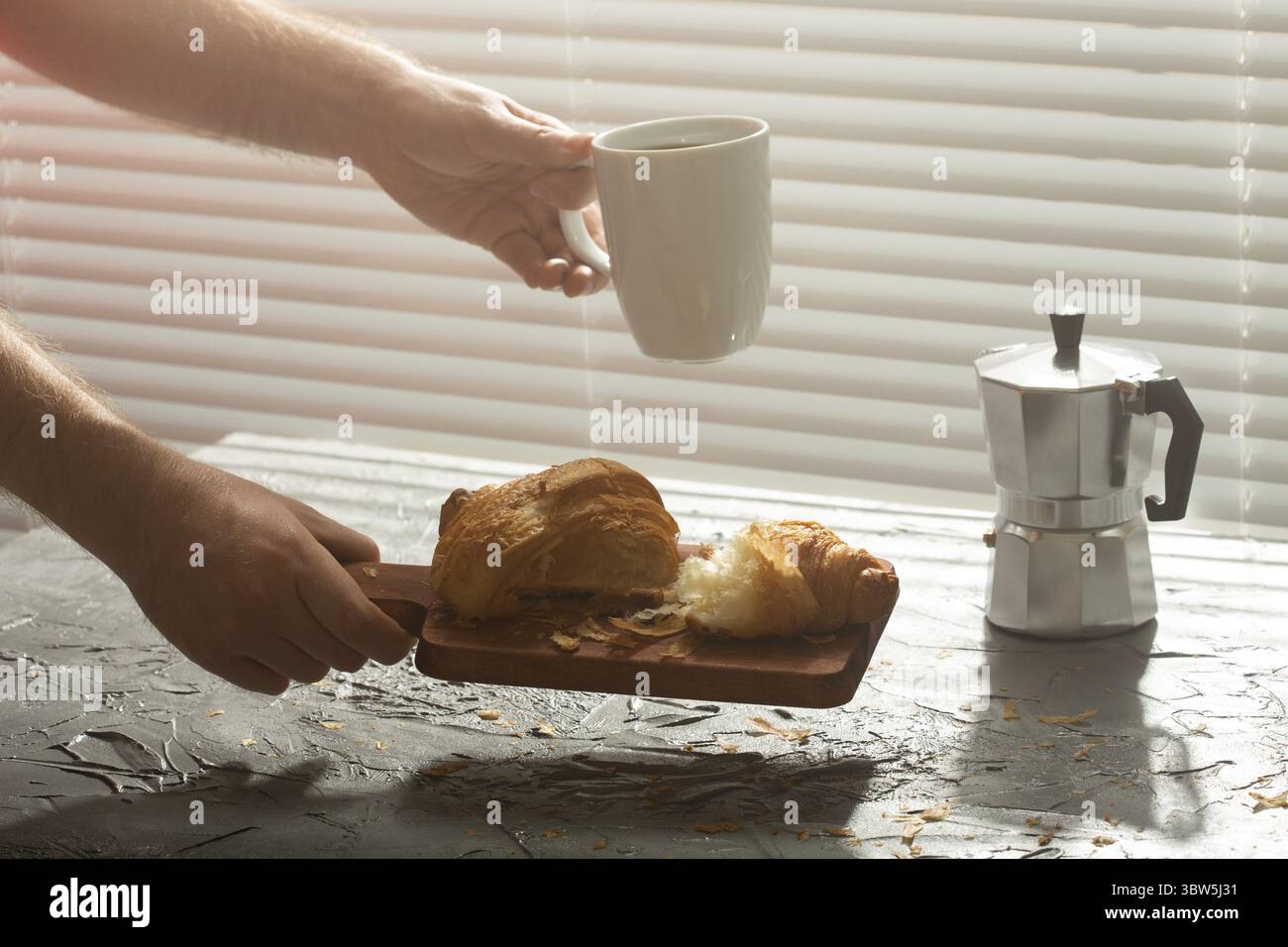 Fruehstueck mit Croissant auf Schneidebrett und schwarzem Kaffee. Morgenessen und Fruehstueck Konzept Foto Stock