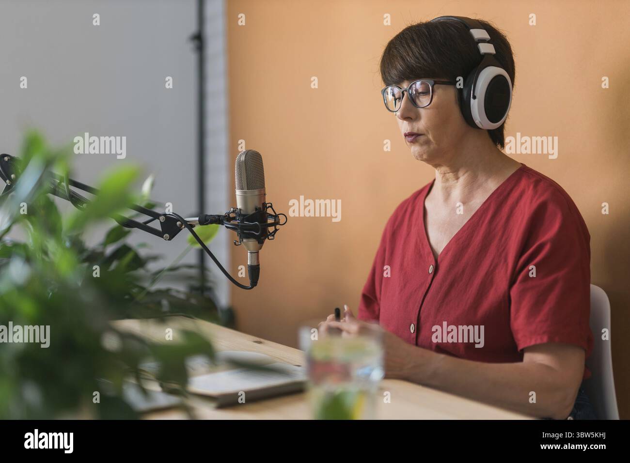 Mittelalterliche Frau radio Gastgeber machen Podcast Aufnahme fuer Online-Show - Broadcast e dj Konzept Foto Stock