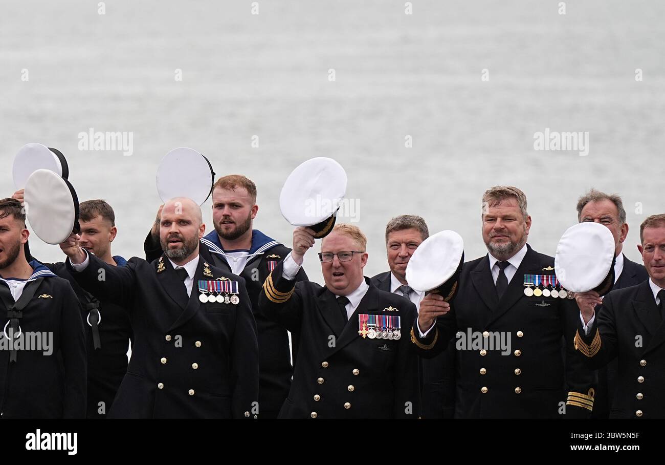 La compagnia della nave regala una tradizionale "Cheer Ship" della Royal Navy per la regina Camilla, Lady Sponsor della HMS Astute, durante una visita alla HMNB Devonport a Plymouth, Devon, per segnare la fine della prima commissione del sottomarino, che è la prima commissione più lunga di qualsiasi sottomarino della Royal Navy nella storia, con oltre 15 anni. Data foto: Mercoledì 16 luglio 2025. Foto Stock