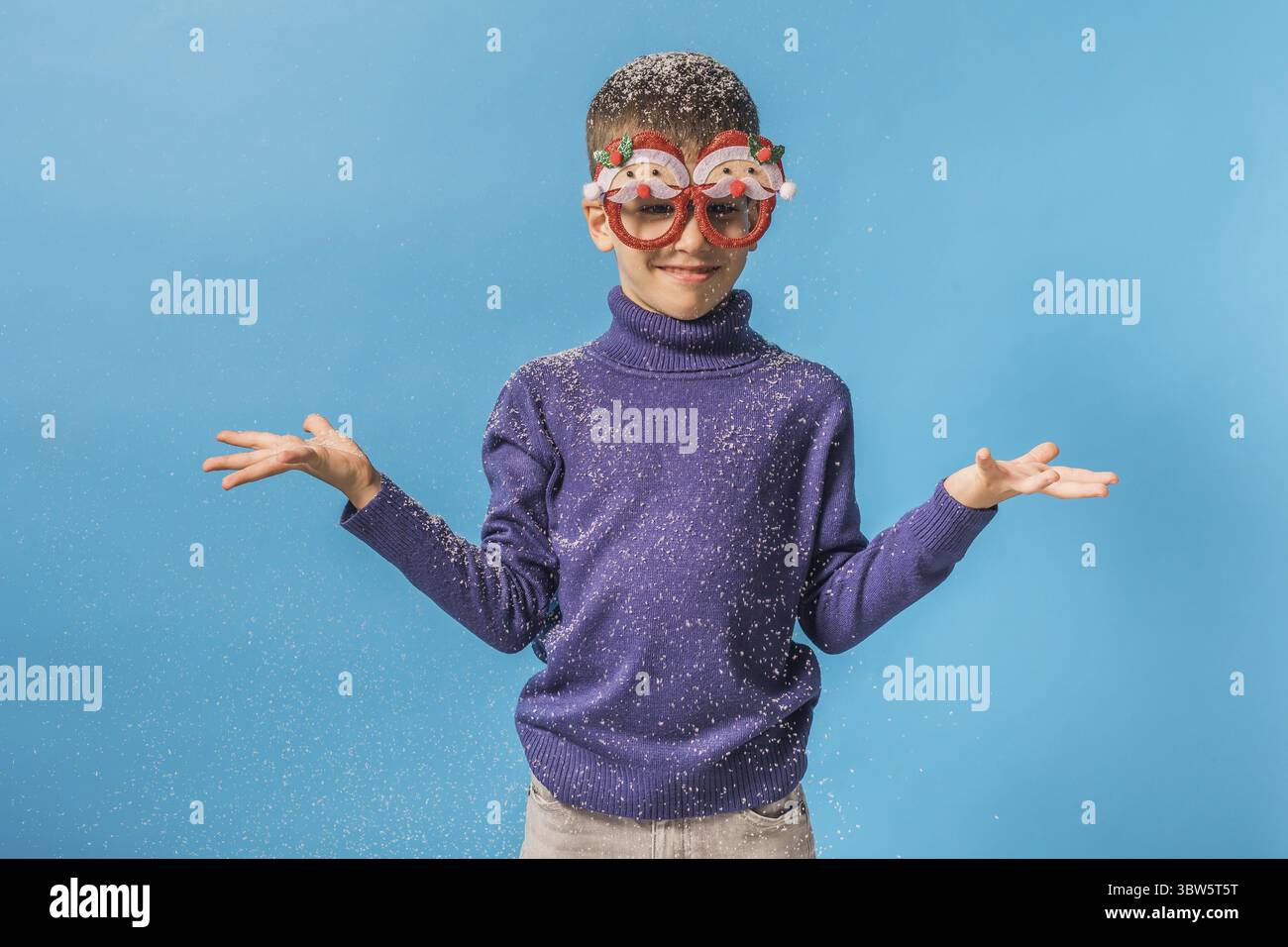 Il bambino vomita su sfondo blu. Natale e Capodanno. Generazione alfa e generazione alfa bambini. Copia spazio Foto Stock