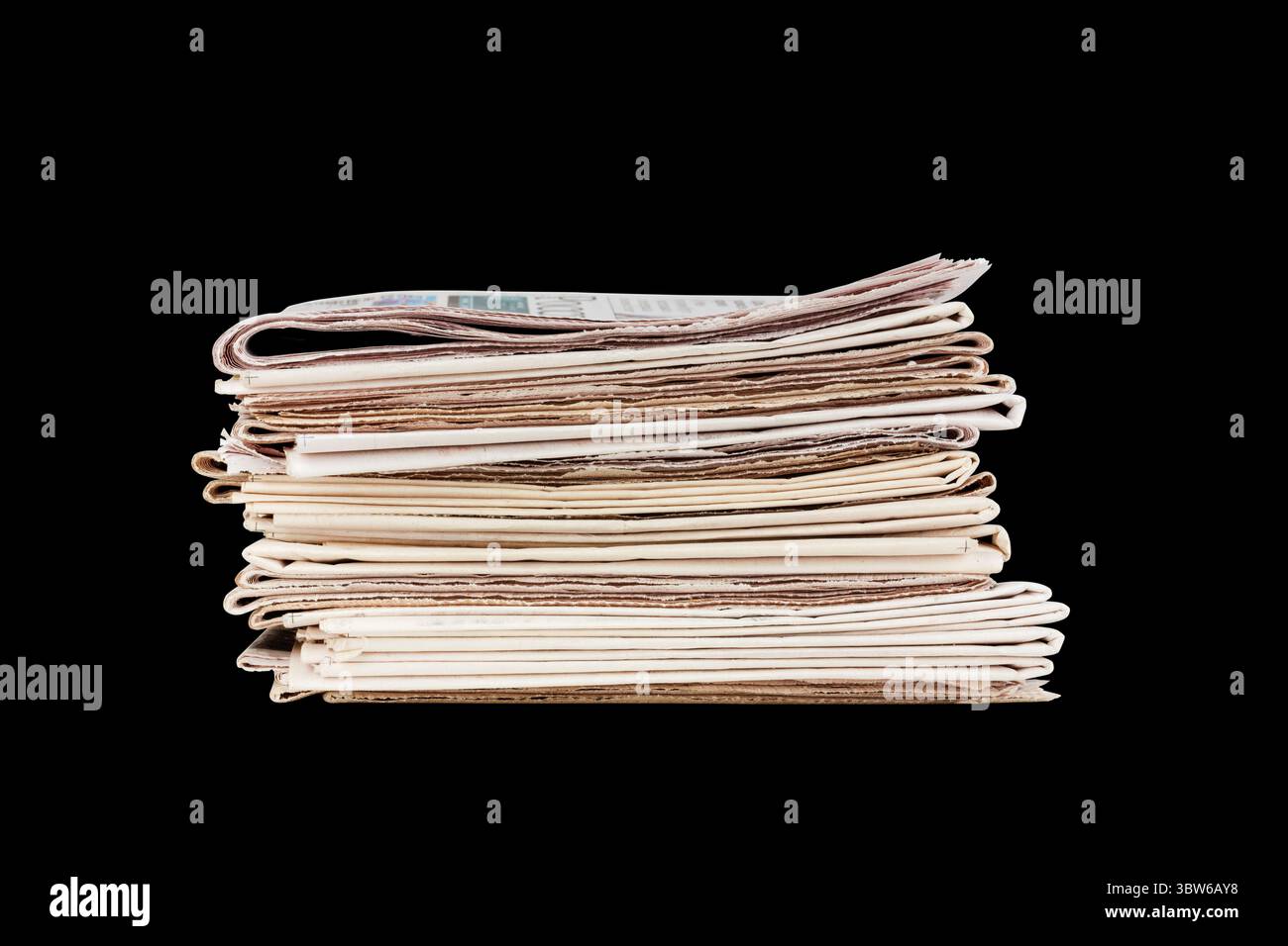 una pila di giornali isolati su sfondo nero Foto Stock