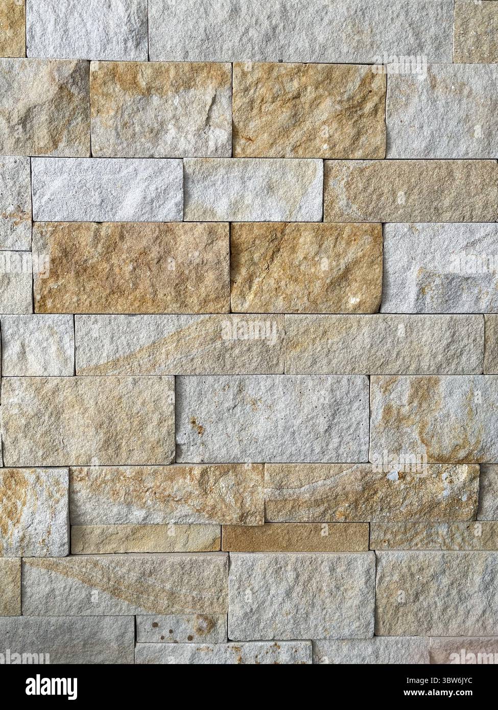 Primo piano di un muro di pietra che mostra vari toni e texture terrosi. Sfondo per spazi di testo o copia e spazio vuoto per la pubblicità Foto Stock