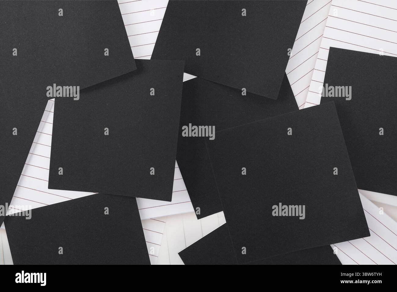 Carta nera sparsa su blocco note Foto Stock