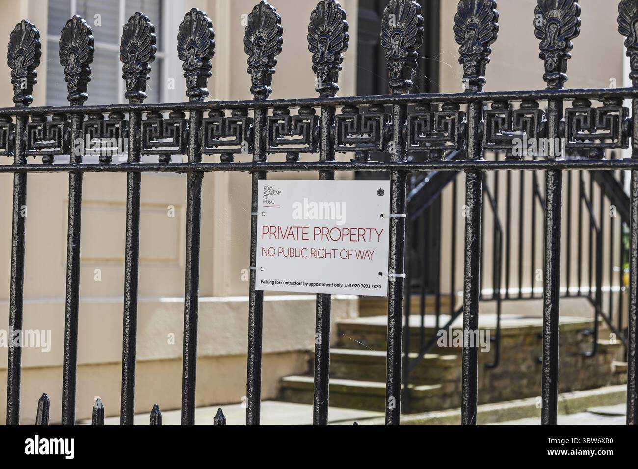 Cartello di proprietà privata montato su un cancello decorativo in ferro che indica l'accesso limitato ai terreni residenziali Foto Stock