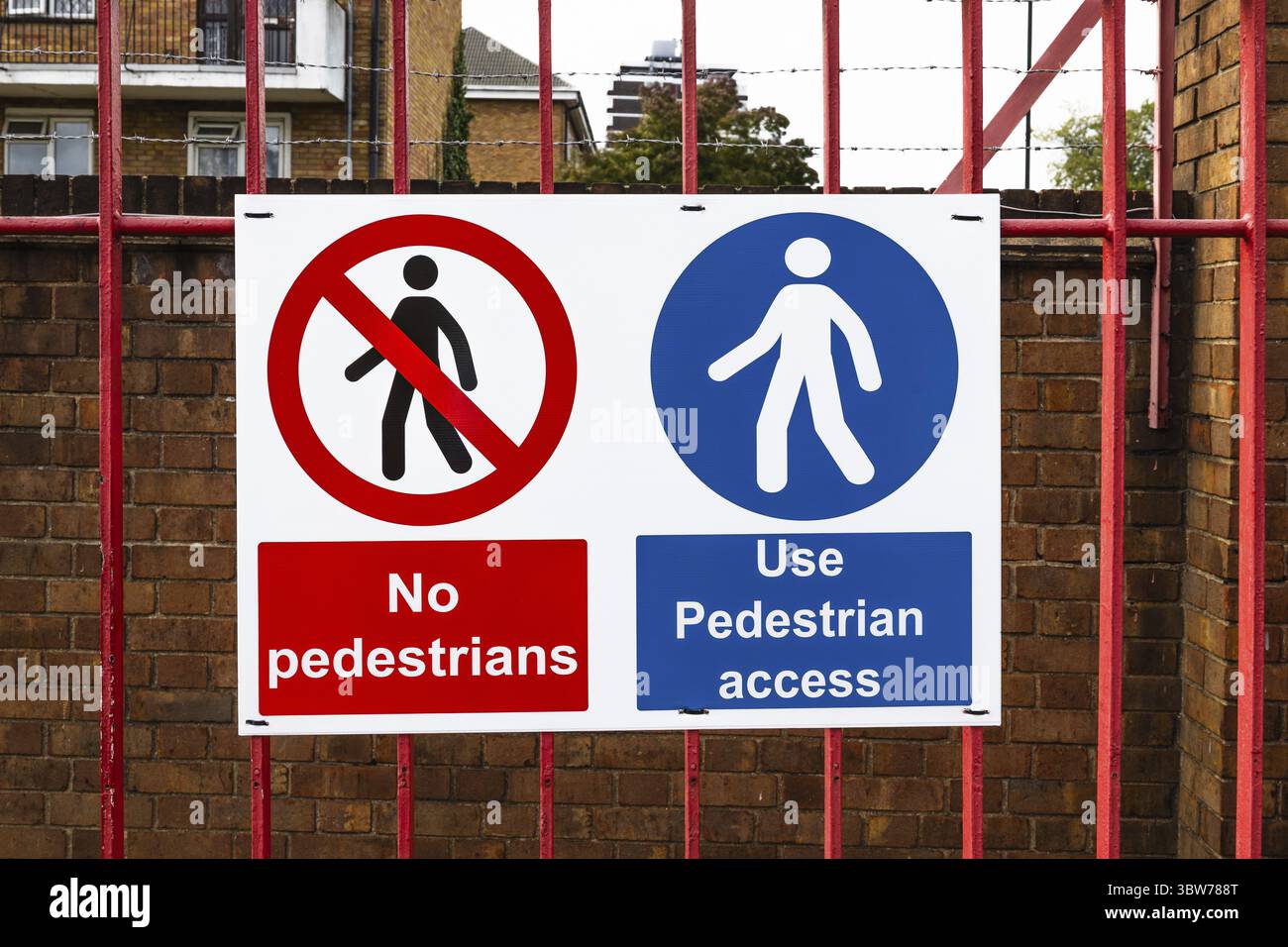 Nessuna zona pedonale e segnale di accesso pedonale montato su una recinzione metallica rossa in un'area residenziale urbana Foto Stock
