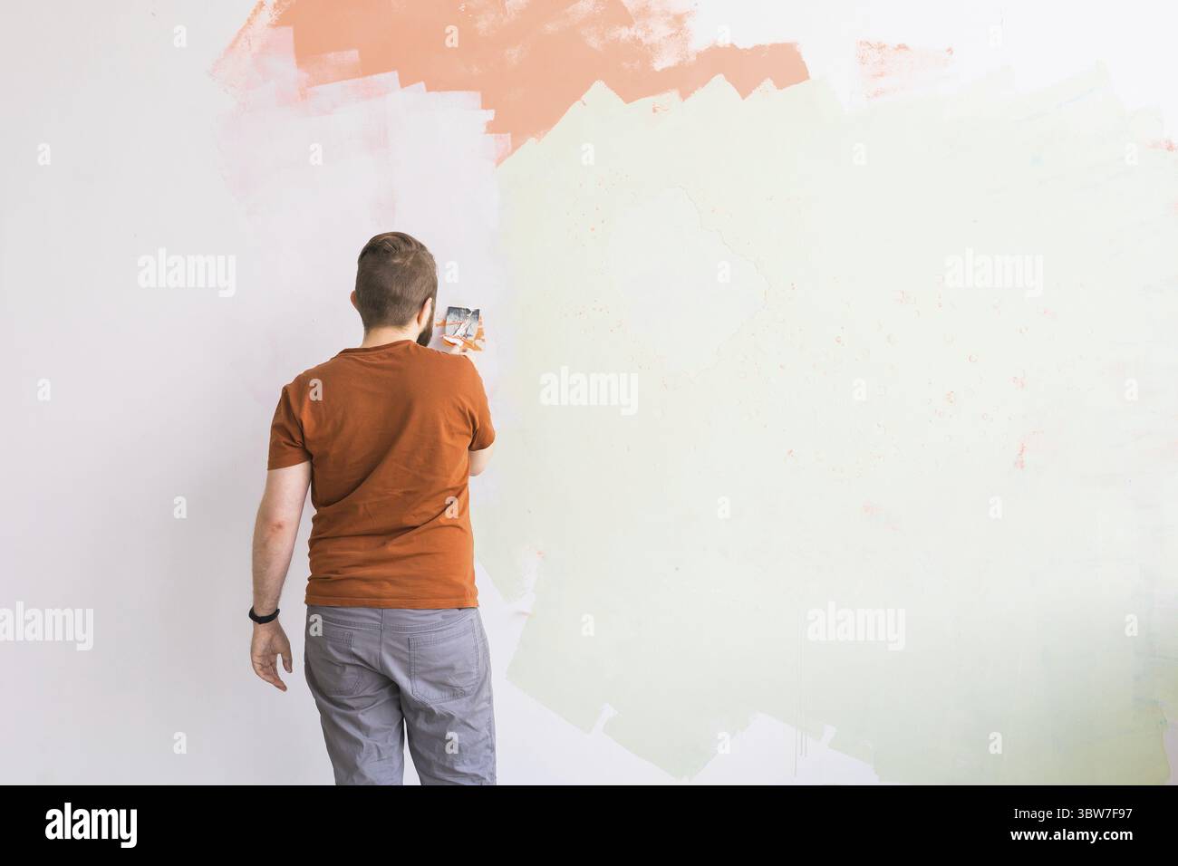 Junger Mann mit Spachtel und Putz der Wand mit weisser, frischer Veredelung Putty. Nahaufnahme. Reparaturarbeiten von zu Hause. Leerer Platz Fuer Text Foto Stock