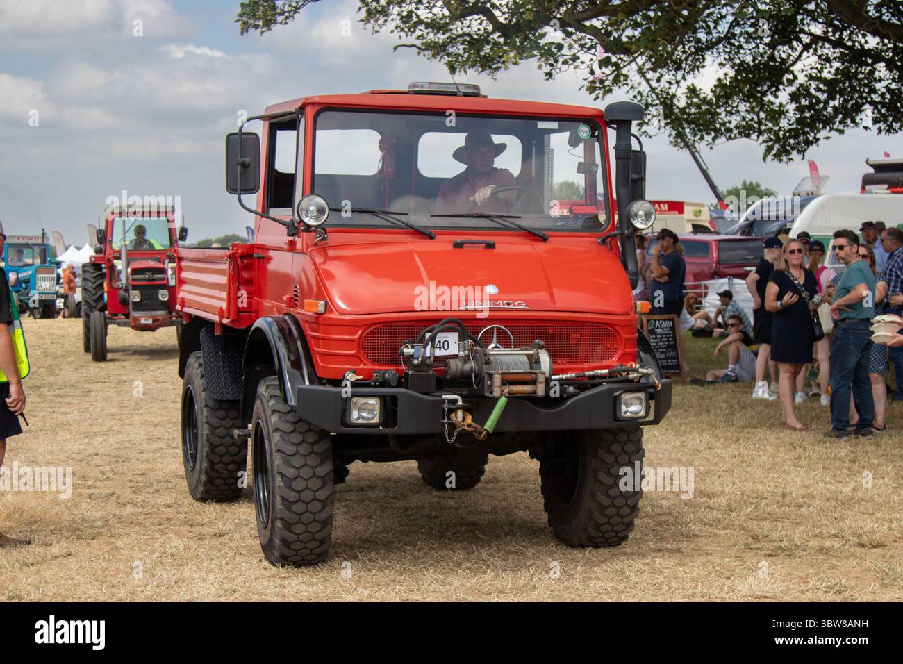 Una Mercedes Benz unimog 406 rossa guidata in una manifestazione di trattori in una giornata di sole. Foto Stock