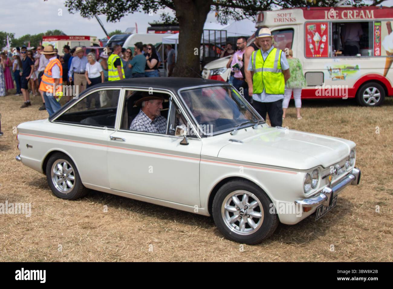 Una Hillman Imp bianca decappottabile ad una fiera campestre del Regno Unito, ha superato la folla durante una mostra di auto d'epoca che celebra il patrimonio automobilistico britannico. Foto Stock
