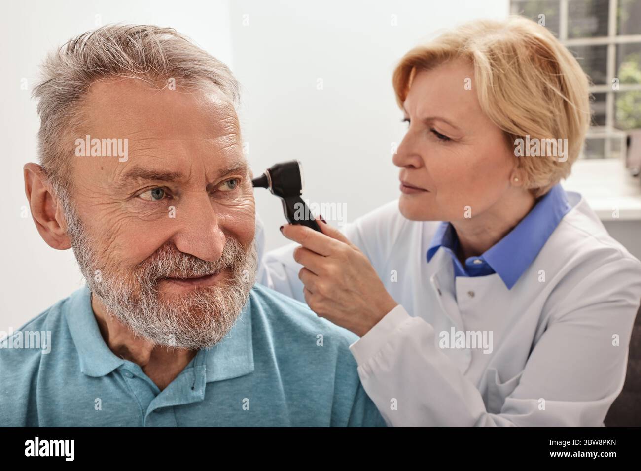 Test dell'udito per persone mature, otoscopia. Otolaringoiatra medico che controlla l'orecchio dell'uomo anziano utilizzando l'otoscopio presso la clinica medica Foto Stock