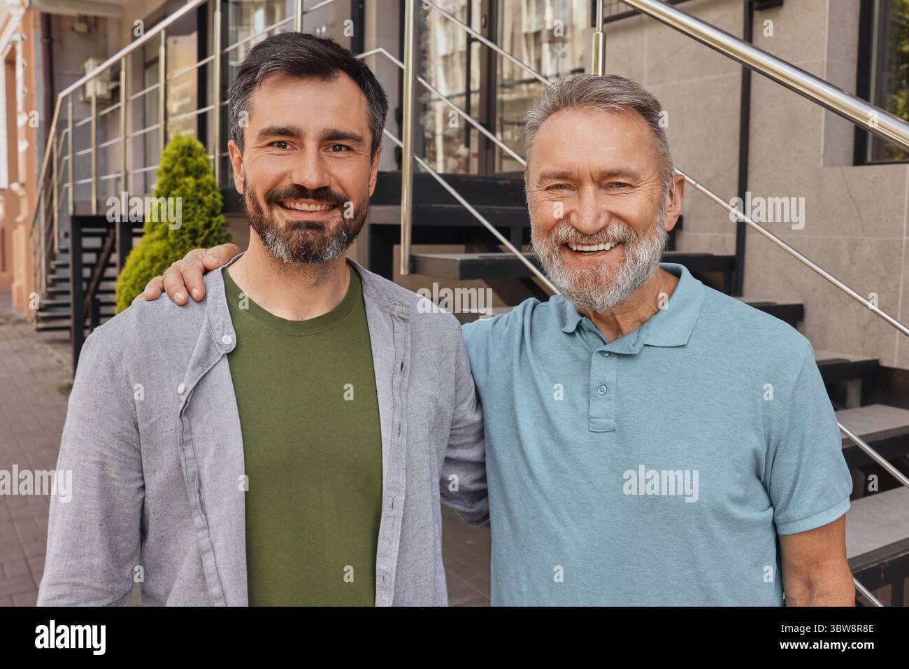 Due amici che si abbracciano e parlano per strada in una città trafficata, utilizzando apparecchi acustici in mezzo ai suoni della città Foto Stock