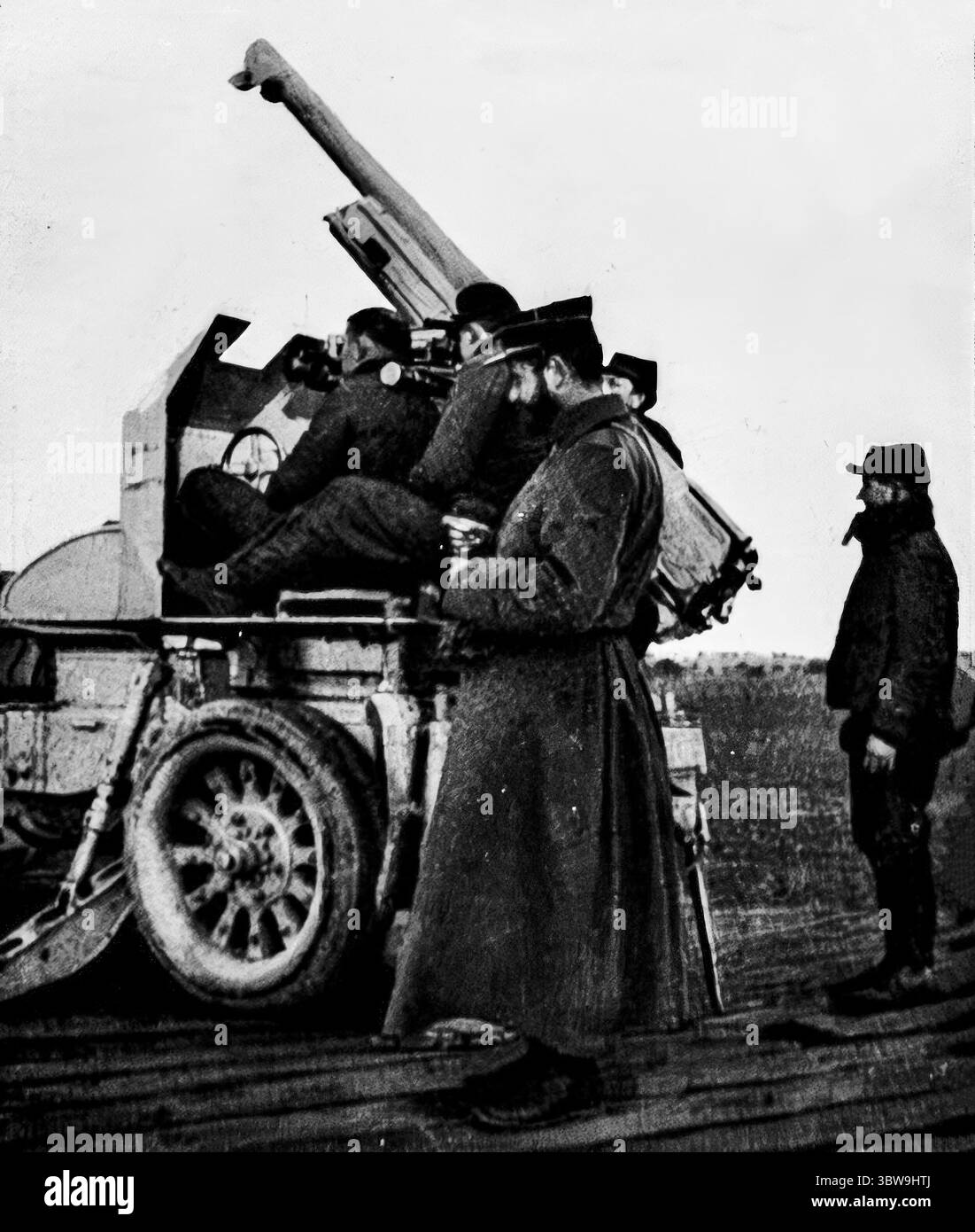 L'equipaggio di auto-canoni francesi si prepara a sparare contro gli aerei nemici, prima guerra mondiale. L'ufficiale comandante calcola con un cronometro, due cannoni sono seduti ai comandi di puntamento e il caricatore è pronto. Pubblicato su l’Illustration, 26 febbraio 1916. Foto Stock