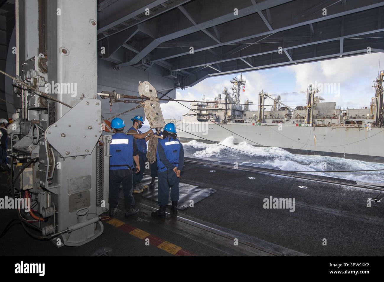 11 novembre 2020 - Oceano Atlantico - i marinai assegnati alla portaerei USS Gerald R. Ford (CVN 78) attaccano la linea a un padeye scorrevole nella baia dell'hangar della nave durante un rifornimento in mare con la nave di supporto da combattimento veloce USNS Arctic (T-AOE 8), 11 novembre 2020. Sotto la guida del Carrier Strike Group 12, Gerald R. Ford è in corso nell'Oceano Atlantico conducendo per la prima volta operazioni di gruppo di attacco integrato con il Carrier Air Wing 8, il Destroyer Squadron 2 e il loro comandante della difesa aerea e missilistica, comandante della USS Gettysburg (CG 64). (Immagine credito: Foto Stock