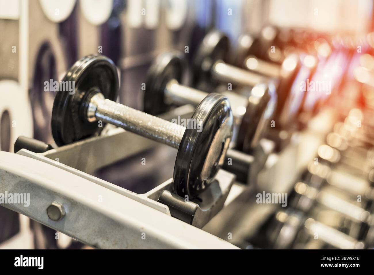 Close up nero metallizzato con manubri in acciaio set. Manubri su rack in sport fitness center. Formazione di allenamento e palestra per il fitness concetto. Salute e benessere b Foto Stock