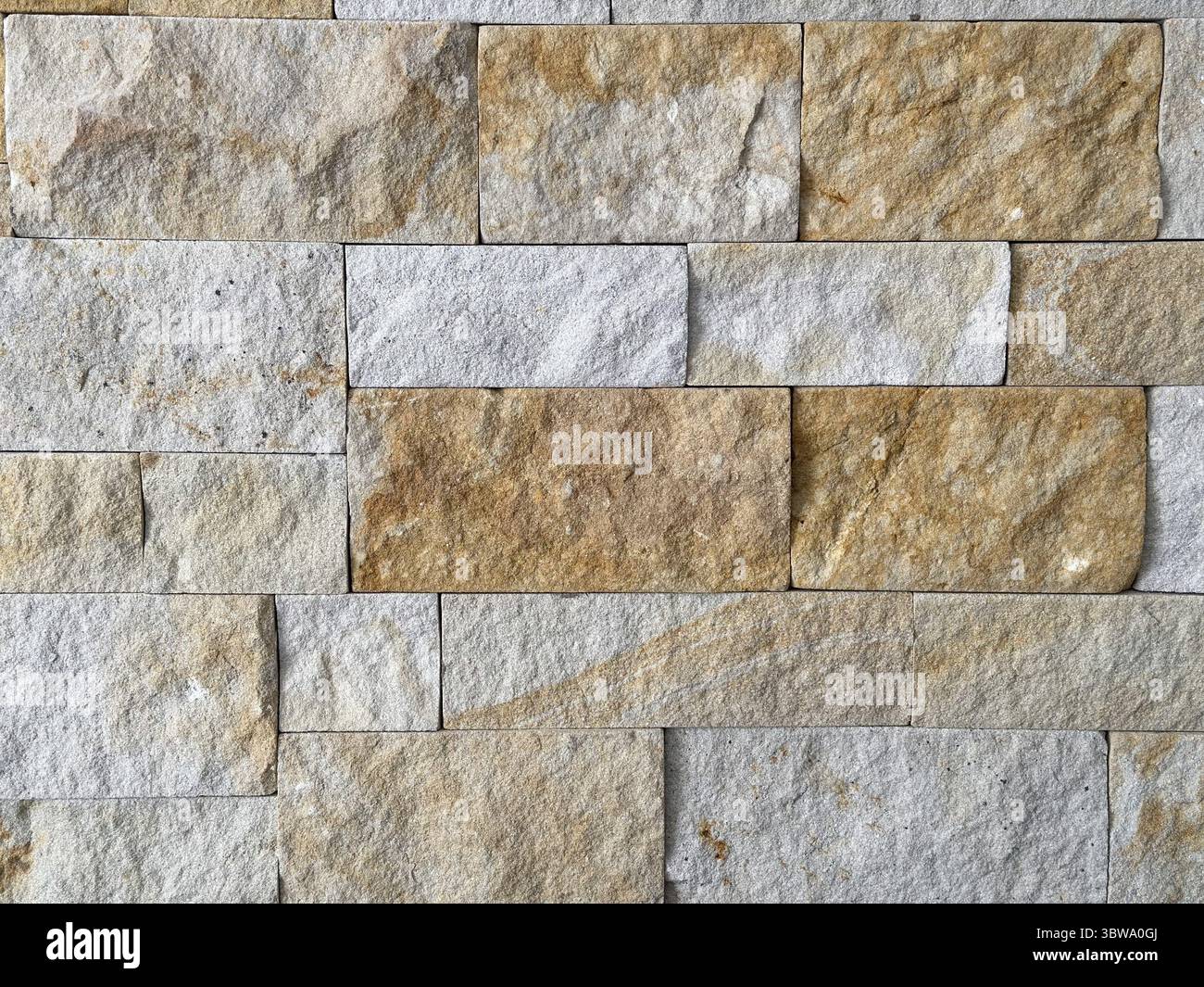 Primo piano di un muro di pietra che mostra vari toni e texture terrosi. Sfondo per spazi di testo o copia e spazio vuoto per la pubblicità Foto Stock