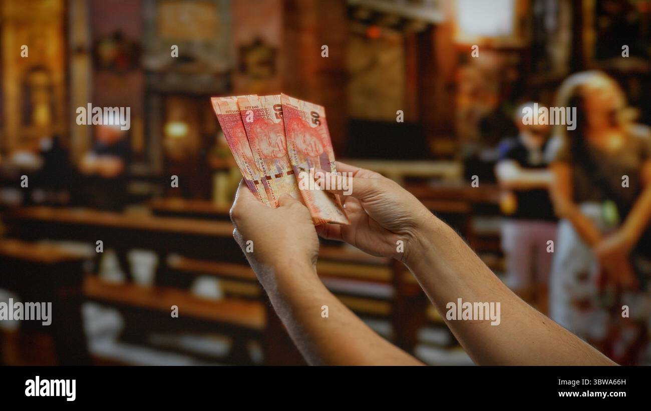 Mani che tengono il rand sudafricano all'interno di una chiesa, illustrano una transazione finanziaria in un ambiente religioso, sottolineano la moneta, l'uomo, Foto Stock