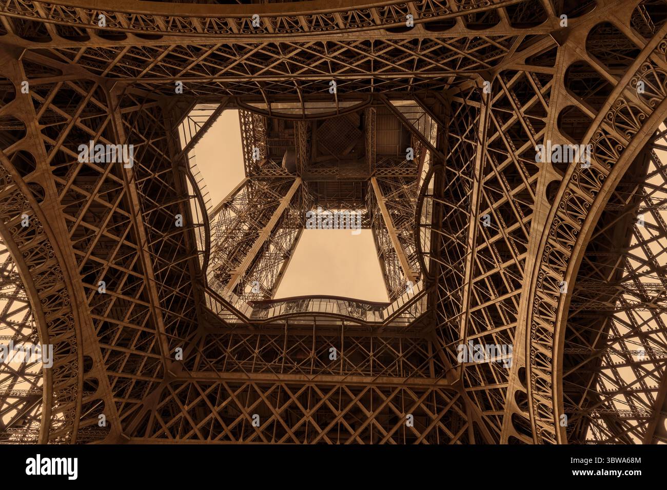 Lavori in ferro e acciaio e design architettonico, in tonalità seppia, della parte inferiore della Torre Eiffel a Parigi, Francia Foto Stock