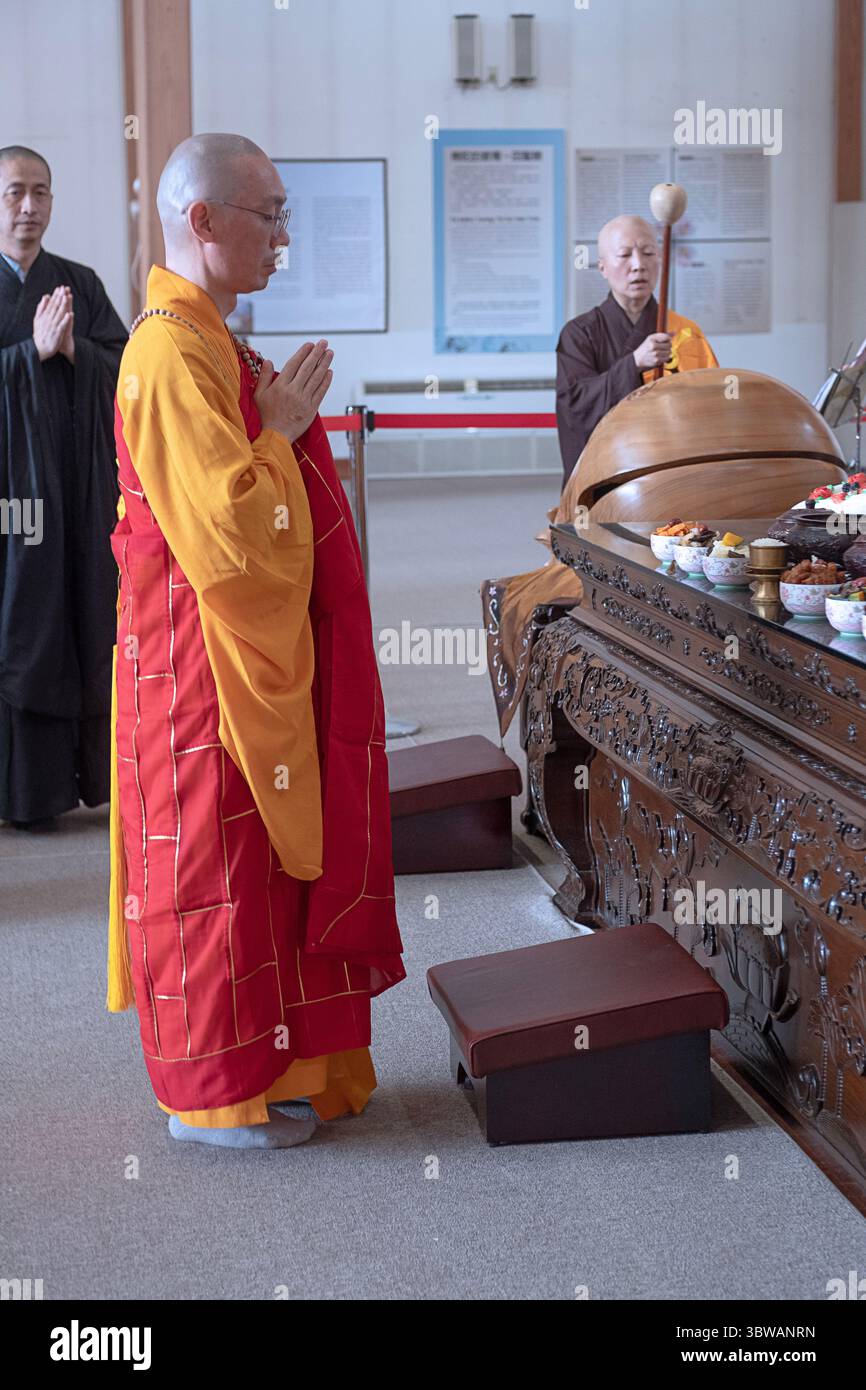 Un sacerdote abate buddista conduce la congregazione ad una cerimonia illuministica di Kuan Yin Bodhisattva in un monastero a Carmel, nella contea di Putnam, New York. Foto Stock