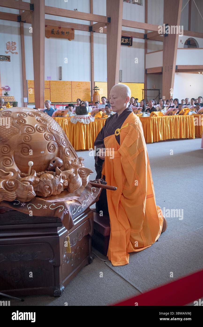 Una suora buddista prega e medita ad una cerimonia illuministica di Kuan Yin Bodhisattva presso il monastero di Chuang Yen a Carmel, nella contea di Putnam, New York. Foto Stock