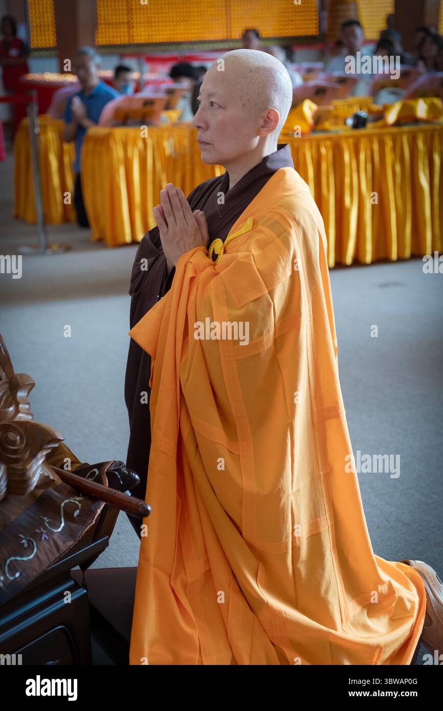 Una suora buddista prega e medita ad una cerimonia illuministica di Kuan Yin Bodhisattva presso il monastero di Chuang Yen a Carmel, nella contea di Putnam, New York. Foto Stock