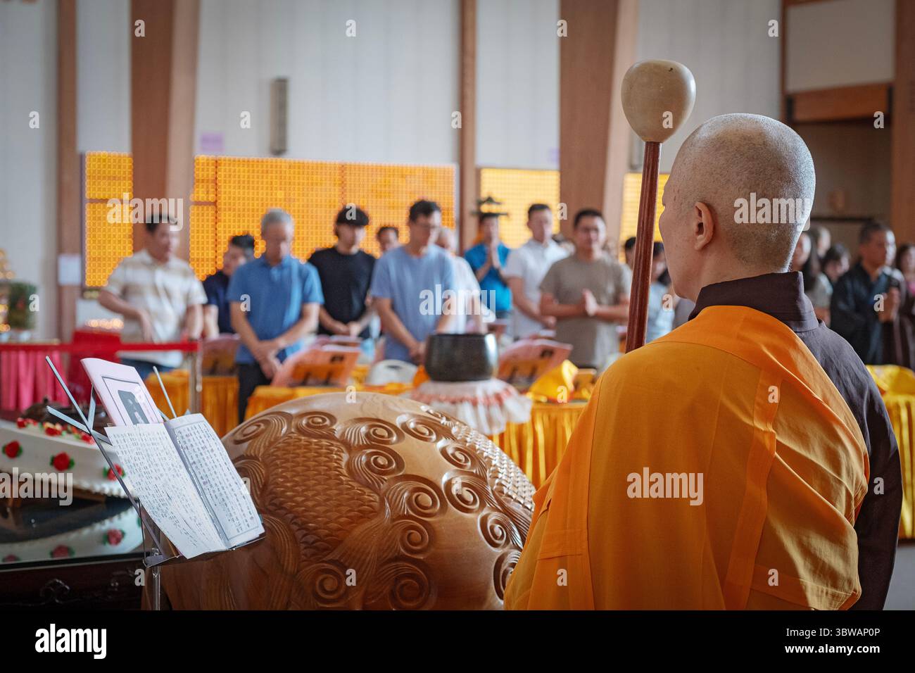 Una suora buddista suora suona il tamburo di legno mougyo in una cerimonia illuministica di Kuan Yin Bodhisattva in un monastero a Carmelo, New York. Foto Stock