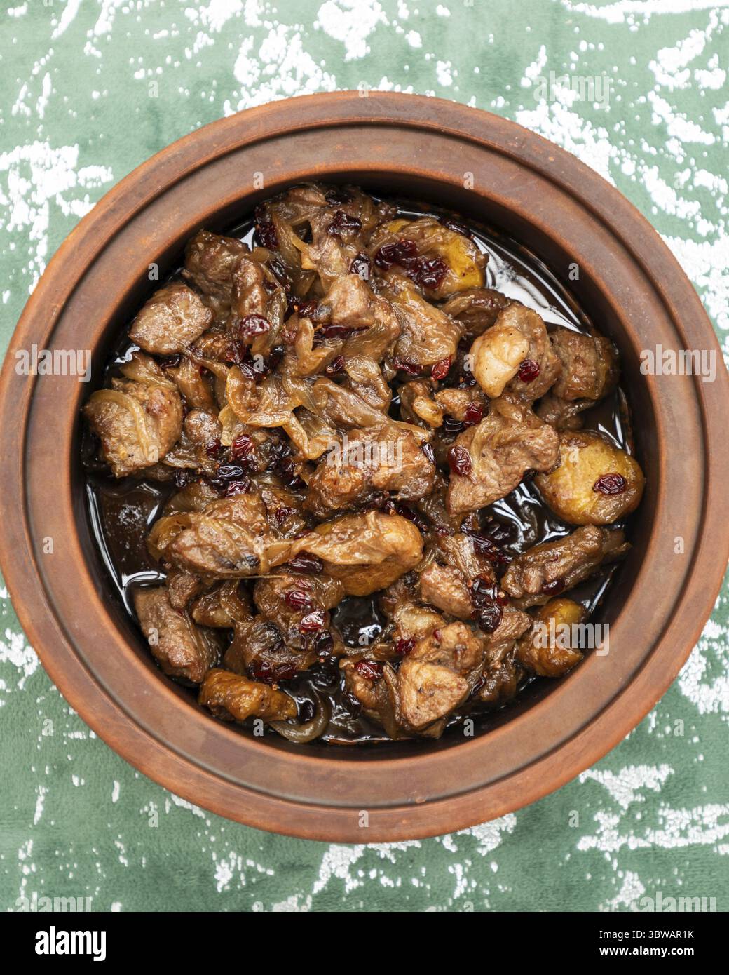 Stufato di manzo con salsa di mirtilli rossi, cipolle e spezie cucinate in una pentola di argilla, che rappresenta la cucina culturale Foto Stock