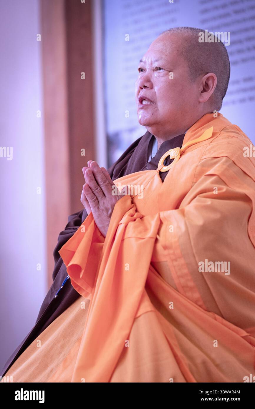 Una suora buddista prega ad una cerimonia illuministica di Kuan Yin Bodhisattva presso il monastero di Chuang Yen a Carmel, contea di Putnam, New York. Foto Stock
