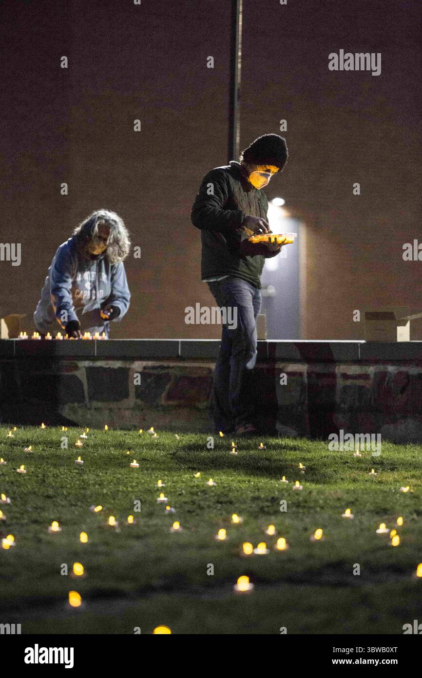 24 novembre 2020, Oneonta, New York, Stati Uniti: Tenali Hrenak (a destra), professore di istruzione Lee Graham e altre facoltà della SUNY Oneonta lanterne a candele luminose nel campus principale quad per rappresentare i casi di COVID-19 del 1.215 fino ad oggi nella contea di Otsego. Alcuni membri della facoltà sono sconvolti perché ritengono che il piano collegeÃs di riaprire per le lezioni di persona in primavera sia pericoloso e irrealistico. Ã piano non è quello di prevenire un'epidemia, solo di individuarla prima che diventi troppo grande. Il problema principale è che questo è pazzesco, se il college avrà il 20% di classi di persona, wonÃt Foto Stock
